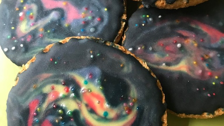 Biscuits with black icing with swirls of colour