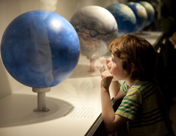 A child looking at Earth globe display 
