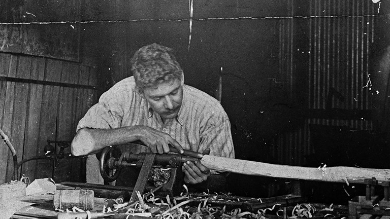 A man using a wood lathe.