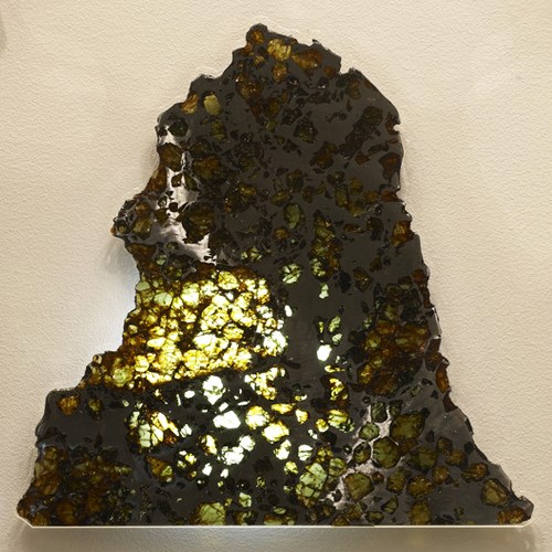 Esquel Stony iron meteorite (Pallasite). The green crystals are olivine set in a iron-nickel alloy.
