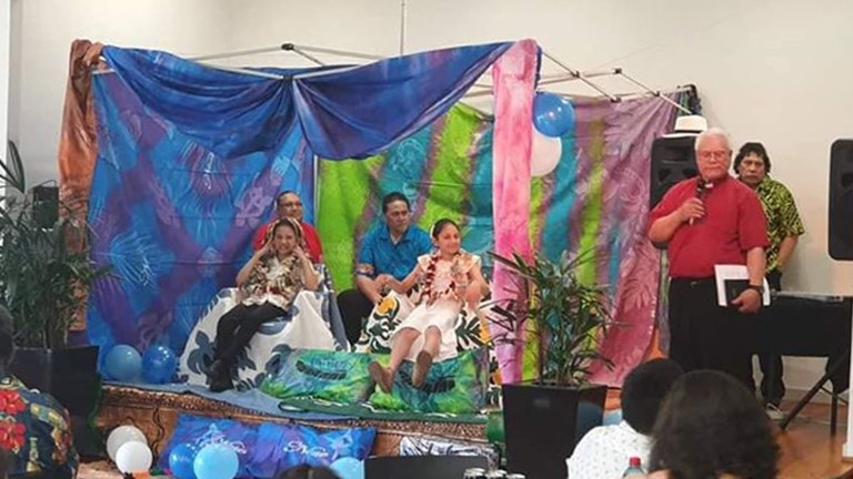 Four people on a stage draped with colourful cloth