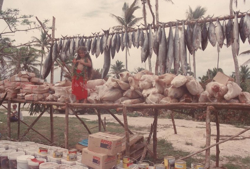 Child standing front of fish and other food