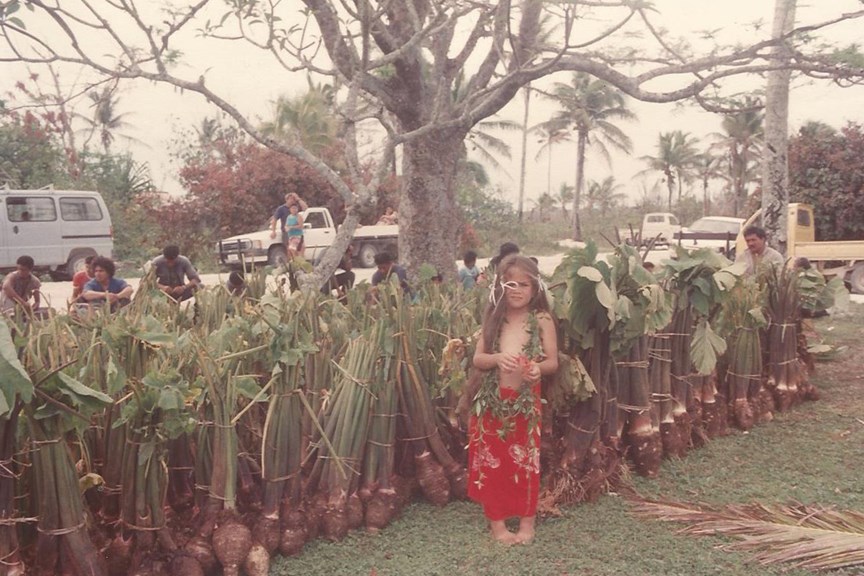 Child standing in front of harvested Taro