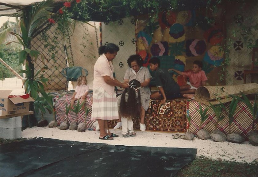 Two woman plaiting a child's hair