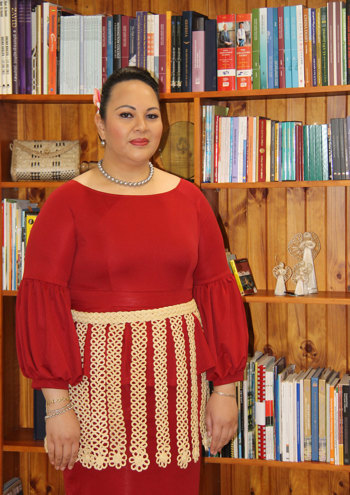 Portrait of a woman wear a red dress standing in front of a bookcase