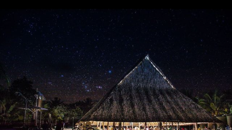 High thatched roof structure without walls at night time