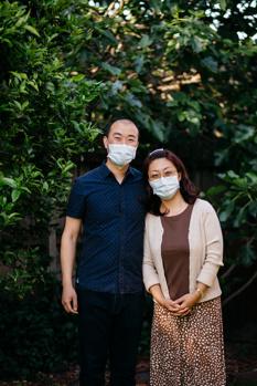 Man and woman standing side by side wear face mask