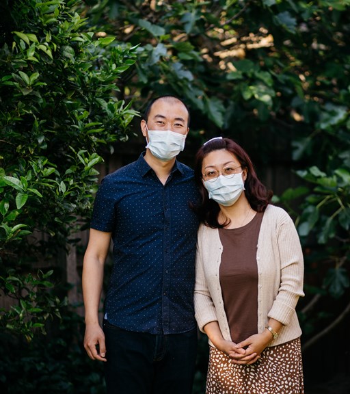 Man and woman standing side by side wear face mask