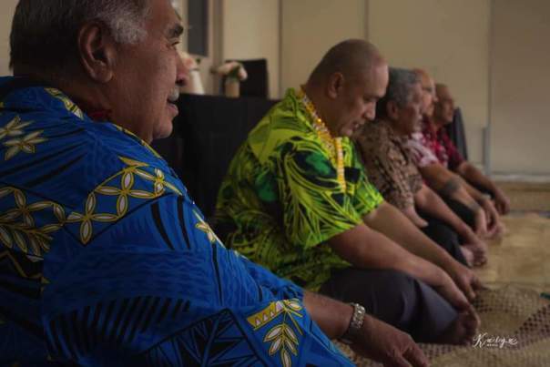 Men sitting cross legged in a row