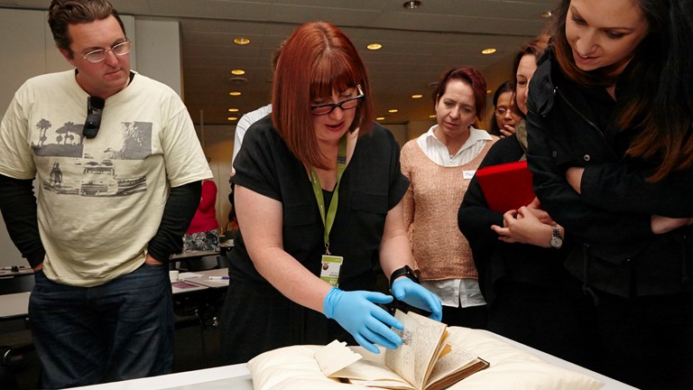 Curator Rebecca Carland presenting rare books at Thinking Without Borders, teacher professional development workshop
