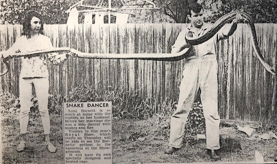 a newspaper clipping of a woman and a man holding a large snake