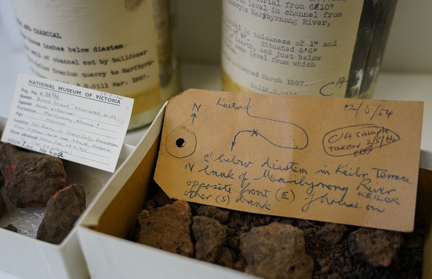 a closeup shot of a sample box filled with earth. A label with a rough hand drawn map indicates where the material came from