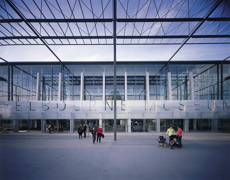 Melbourne Museum glass facade and entrance showing people on the plaza