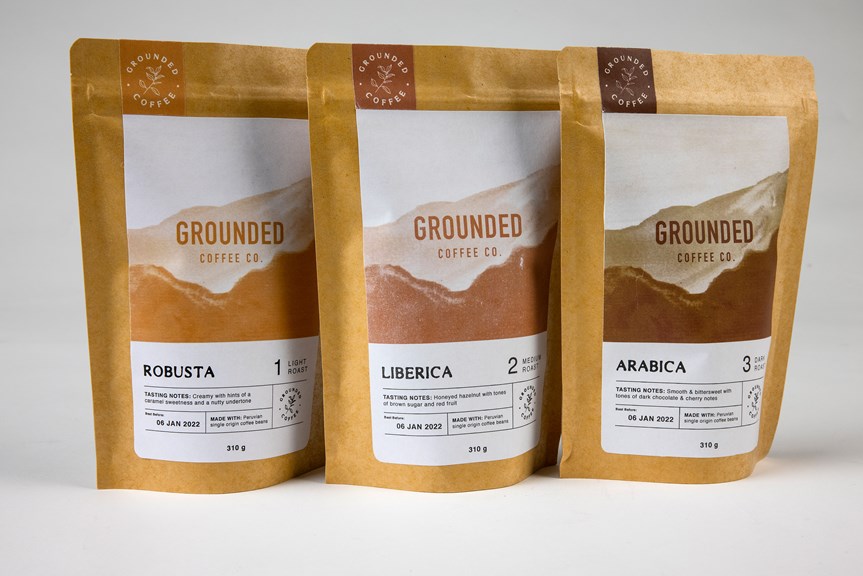 Three bags of coffee are lined up. The packaging is labelled with the Grounded logo and each bag is a different shade of brown to denote the different types of coffee and roast.
