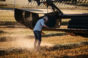 This image is one of 16 photographs of Marlee Langfield of Wallaringa, Cowra, New South Wales, taken by Catherine Forge on 22 October 2018 as part of the Invisible Farmer Project, which included an oral history interview. Farmer Marlee Langfield in the paddock cleaning debris from the mouth of a combine harvester. Machine maintenance like this constitutes one of Marlee's many roles on the farm and is important for the success of a harvest.
