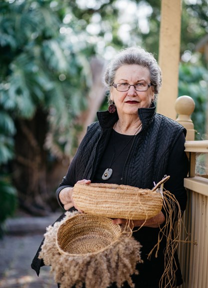 Woman holding to woven baskets
