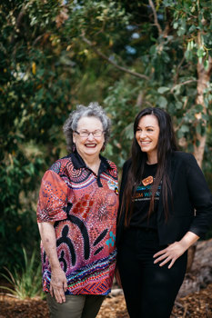 Two woman standing side by side smiling