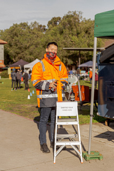 Man in high-vis at a hand sanitising station