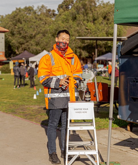 Man in high-vis at a hand sanitising station