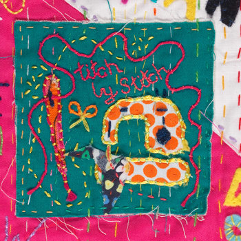 Detail of embroidered quilt showing a sewing machince
