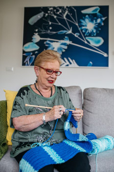 Woman sitting on the couch knitting