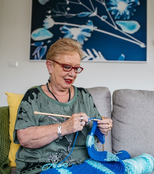 Woman sitting on the couch knitting
