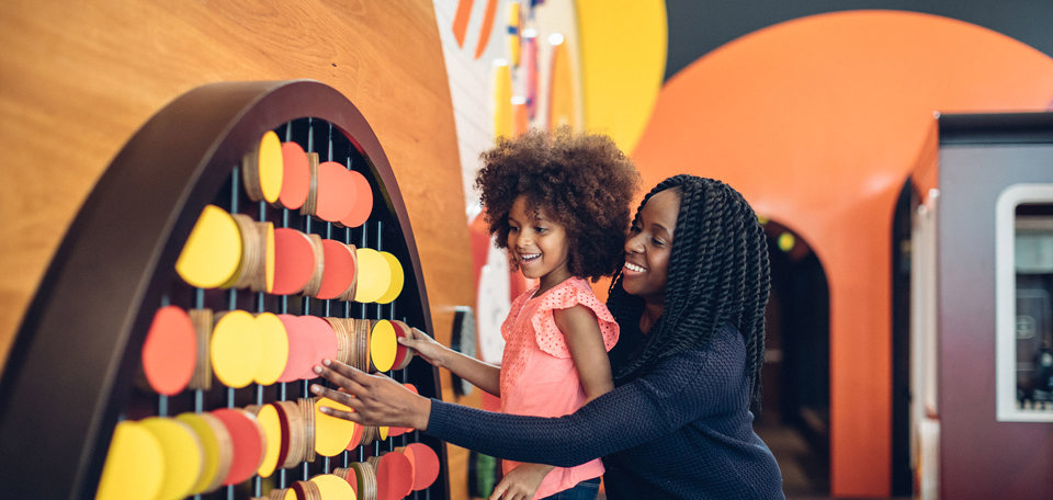 Mother and daughter playing with circular wooden blocks at the Pauline Gandel Children's Gallery, Melbourne Museum.