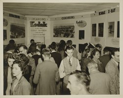 Oblique view of men and women looking at Kodak display.