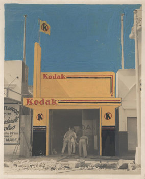 A Kodak shop front being constructed. The building and the sky have been hand coloured