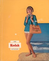 Cover of a catalogue. It has a yellow background with a cut out image of a woman standing on the beach holding a camera and a Kodak bage. 