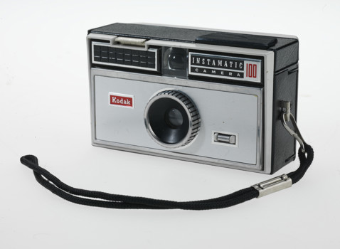 Small rectangular box camera. It is black and silver.