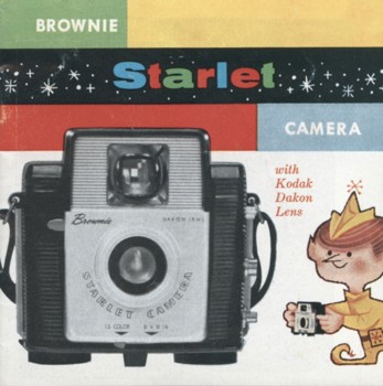 The cover of a paper brochure printed in full colour with a small cartoon 'Brownie' creature (like an elf) on the cover, next to a large image of the camera.