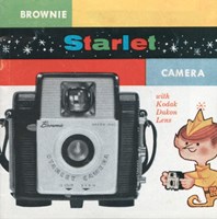 The cover of a paper brochure printed in full colour with a small cartoon 'Brownie' creature (like an elf) on the cover, next to a large image of the camera.