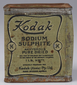 A rectangular tin paint a olive green with a black printed label on the front