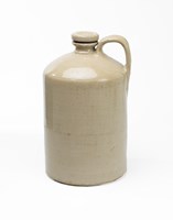 Cream stoneware jar with handle and a round lid that screws into the neck of the jar.