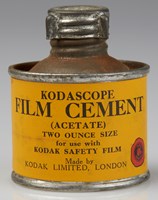 Small round tin bottle with a yellow label with black text