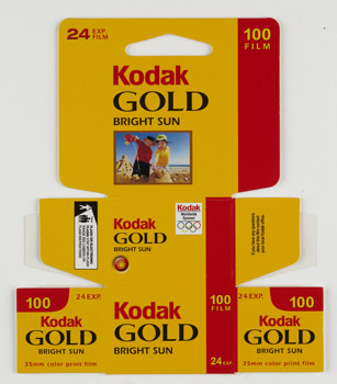 Bundle of 10 un-used, flat pack boxes printed in a yellow, red and black colour scheme with a photograph on the front of a two boys making sandcastles on the beach. 