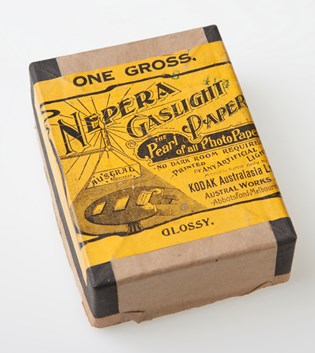 Rectangular brown cardboard box with yellow and black label.