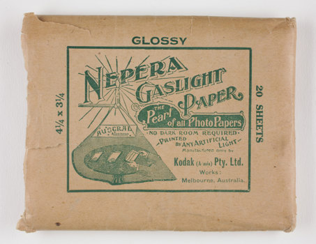 Rectangular brown paper envelope with green printed text, torn open at one end.