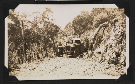 Man standing next to a car in the bush