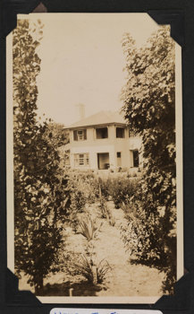 A view of a large house with garden in the foreground