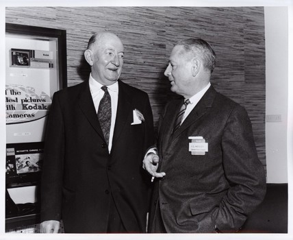 Two men standing and looking at each other speaking