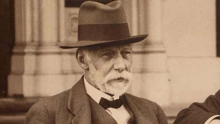 A bearded man in a hat and bow tie