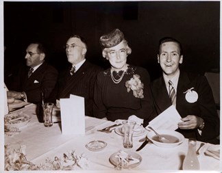 Man and a woman seated at a table set for a dinner function
