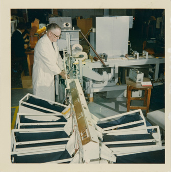 Man in a white lab coat using a machine