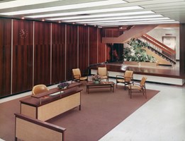 Interior with a desk and arm chairs and wood panel feature wall