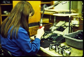 woman wear a blue uniform using tools to make a camera