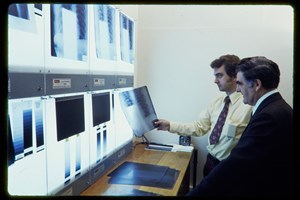 Two men looking at x-rays on a lightbox
