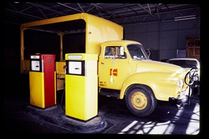Yellow truck being refueled at yellow and red bowsers