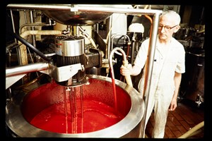 Man standing nest to a large vat of red liquid